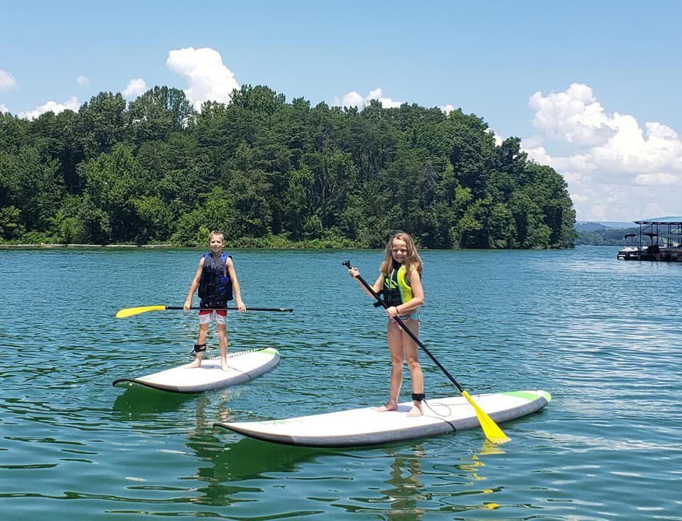 A boy and a girl on paddleboards